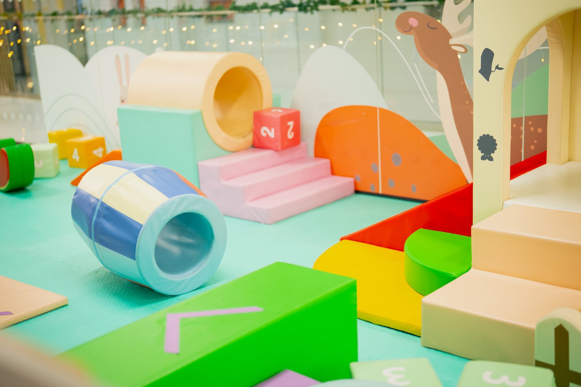 Modern indoor playground featuring pastel foam shapes soft tunnels steps and slides creating safe environment for kids play and development