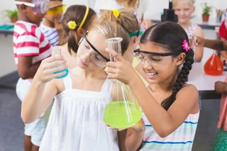 Kids doing a chemical experiment in laboratory at school