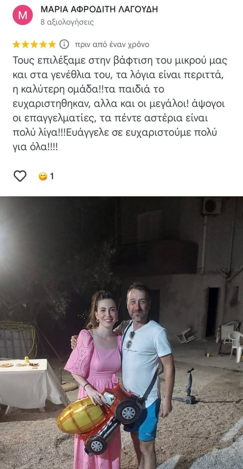Woman in pink dress and man in light blue shirt holding toy cars at outdoor celebration